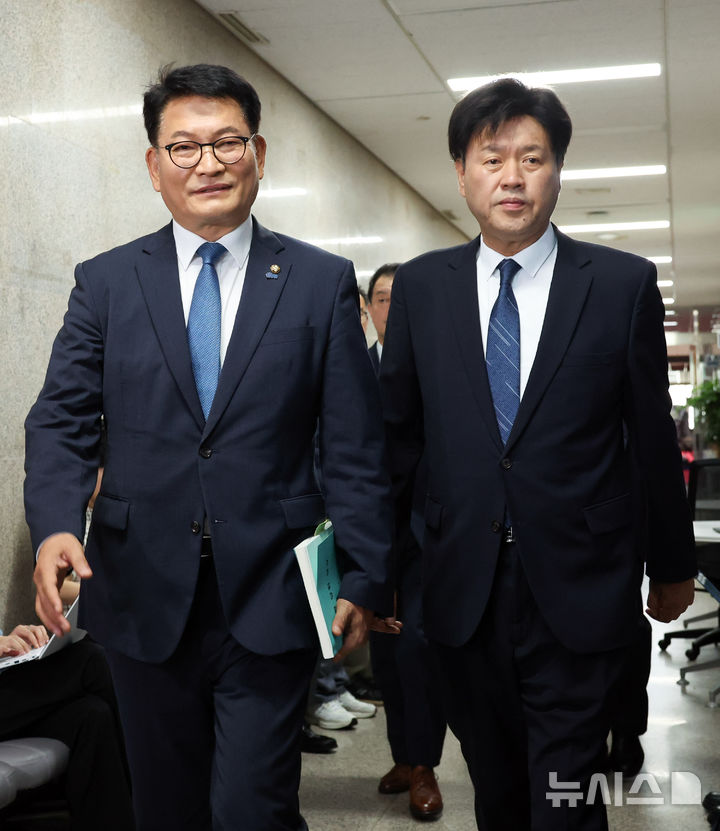 [서울=뉴시스] 최진석 기자 = 더불어민주당 당권주자인 송영길(왼쪽) 의원이 17일 비공개 최고위원회의가 열린 여의도 국회 민주당 대표회의실 로 민주당 강령·당헌·당규집을 들고 김용 전 민주연구원 부원장과 이동하고 있다. 2026.07.17. myjs@newsis.com