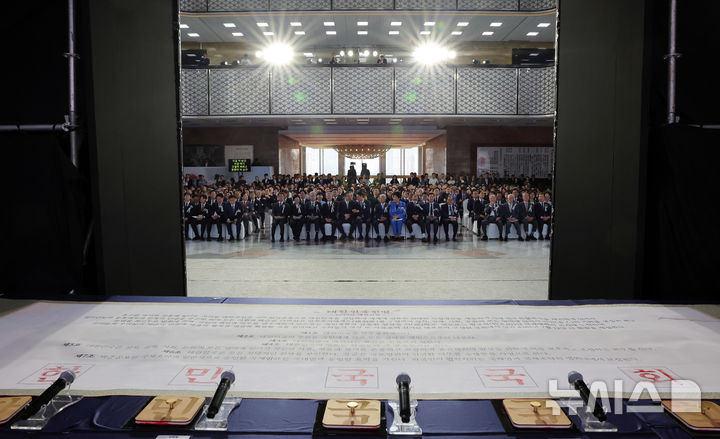 [서울=뉴시스] 국회사진기자단 = 17일 서울 여의도 국회에서 열린 제78주년 제헌절 경축식에서 국회 여야 대표와 원내대표들이 도장 날인한 제헌헌법이 보이고 있다. 2026.07.17. photo@newsis.com