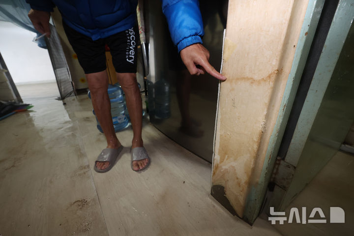 [고양=뉴시스] 김명년 기자 = 18일 새벽부터 내린 집중호우로 침수된 경기 고양 화전동 주택가에서 한 주민이 침수피해 흔적을 손가락으로 가리키고 있다. 2026.07.18. kmn@newsis.com