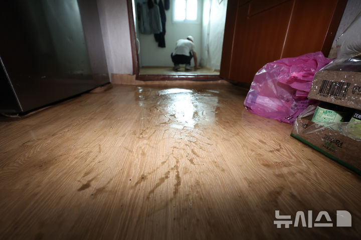 [고양=뉴시스] 김명년 기자 = 18일 집중호우로 침수피해를 입은 경기 고양 화전동 주택가에서 한 주민이 방바닥을 걸레로 닦고 있다. 2026.07.18. kmn@newsis.com