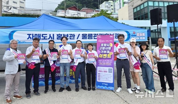 [포항=뉴시스] = 포항시는 17~19일 사흘간 저동여객선터미널 일원에서 열린 '제24회 울릉도 오징어 축제'에 참가해 자매 도시 간 상생 협력을 다지고 포항의 우수한 관광 자원과 특산물 등을 홍보했다. 사진은 울릉도 오징어 축제 포항 홍보관 앞에서 신강수 포항시 푸른도시사업단장과 직원, 임주희 포항시의회 의회운영위원장과 포항울릉향우회원이 기념 촬영하고 있다. (사진=포항시 제공) 2026.07.19. photo@newsis.com 