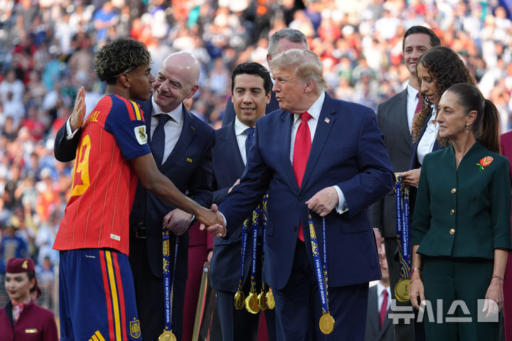 [이스트 러더퍼드=AP/뉴시스] 잔니 인판티노 국제축구연맹(FIFA) 회장(왼쪽)과 도널드 트럼프 미국 대통령이 19일(현지시간) 미 뉴저지주 이스트러더퍼드에서 열린 2026 북중미 월드컵 결승전이 끝난 뒤 스페인의 라민 야말에게 메달을 수여하며 축하하고 있다. 2026.07.20.