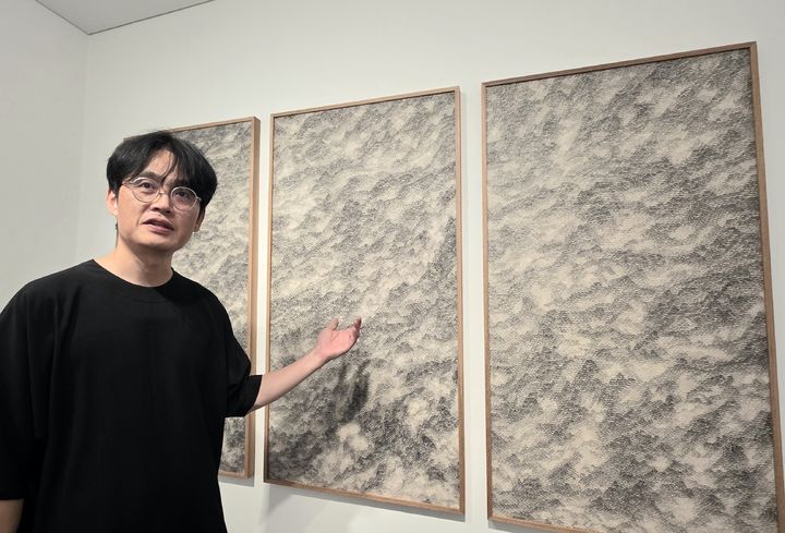 [사진=박현주 미술전문기자] 차영석 작가가 연필선으로 완성한 신작 'Smudge'를 설명하고 있다. 멀리서는 수묵 산수 같고, 가까이서는 끝없이 반복된 연필선의 호흡이 드러난다. 2026.07.20. hyun@newsis.com *재판매 및 DB 금지
