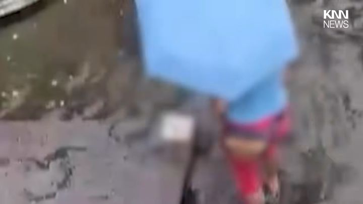 [서울=뉴시스]한 여성이 청계천 한가운데로 들어가 동전을 줍고 있다.(사진=유튜브 'KNN NEWS' 캡처)2026.07.20.