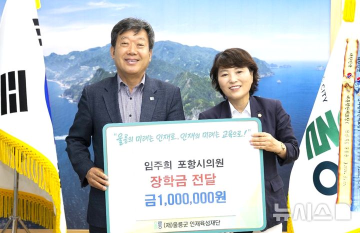 [울릉=뉴시스] = 지난 16일 경북 '울릉도 오징어 축제' 개막식에 참석하기 위해 울릉군을 방문한 임주희 포항시의회 의회운영위원장(오른쪽)이 남한권 울릉군수에게 장학금을 전달하며 기념 촬영하고 있다. (사진=울릉군 제공) 2026.07.20. photo@newsis.com