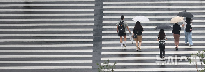 [서울=뉴시스] 조수정 기자 = 전국에 장맛비가 내리는 20일 오전 서울 종로구 광화문 인근에서 시민과 관광객들이 우산을 쓰고 걸어가고 있다. 2026.07.20. chocrystal@newsis.com