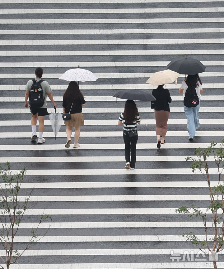 [서울=뉴시스] 조수정 기자 = 전국에 장맛비가 내리는 20일 오전 서울 종로구 광화문 인근에서 시민과 관광객들이 우산을 쓰고 걸어가고 있다. 2026.07.20. chocrystal@newsis.com