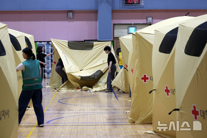 [인천=뉴시스] 고승민 기자 = 인천 서해구 석남동 쿠팡32물류센터 화재 사흘째인 20일 신현여자중학교 강당에서 대한적십자사, 쿠팡 등 관계자들이 대피소를 마련하고 있다. 2026.07.20. kkssmm99@newsis.com