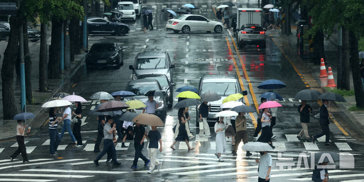 [서울=뉴시스] 조수정 기자 = 전국에 장맛비가 내리는 20일 오후 서울 종로구 도렴동 횡단보도에서 인근 직장인들이 우산을 쓰고 걸어가고 있다. 2026.07.20. chocrystal@newsis.com