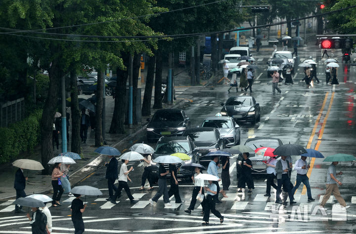 [서울=뉴시스] 조수정 기자 = 전국에 장맛비가 내리는 20일 오후 서울 종로구 도렴동 횡단보도에서 인근 직장인들이 우산을 쓰고 걸어가고 있다. 2026.07.20. chocrystal@newsis.com