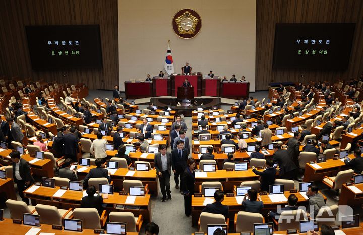 [서울=뉴시스] 고범준 기자 = 윤상현 국민의힘 의원이 20일 서울 여의도 국회에서 열린 제437회 국회(임시회) 제1차 본회의에서 윤석열·김건희에 의한 내란·외환 및 국정농단 행위의 진상규명을 위한 특별검사 임명 등에 관한 법률 일부개정법률안(대안)에 대해 무제한토론(필리버스터)을 하고 있는 가운데 민주당 의원들이 이동하고 있다. 2026.07.20. bjko@newsis.com