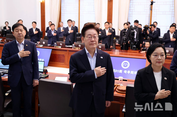 [서울=뉴시스] 김진아 기자 = 이재명 대통령이 21일 청와대에서 열린 국무회의에서 국민의례를 하고 있다. 왼쪽부터 구윤철 부총리 겸 재정경제부 장관, 이 대통령, 한성숙 국무총리. (청와대통신사진기자단) 2026.07.21. bluesoda@newsis.com