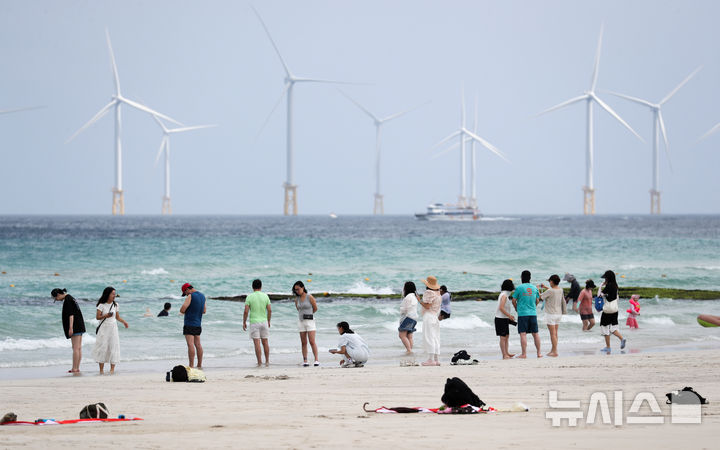 [제주=뉴시스] 우장호 기자 = 장마가 소강상태에 놓인 21일 오전 제주시 한림읍 협재해수욕장에서 관광객들이 물놀이를 하며 더위를 식히고 있다. 2026.07.21. woo1223@newsis.com