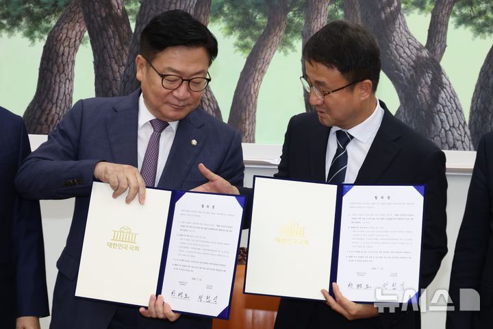[서울=뉴시스] 최진석 기자 = 한병도(오른쪽) 더불어민주당 대표 직무대행 겸 원내대표와 정점식 국민의힘 원내대표가 21일 국회 운영위원장실에서 제9회 전국동시지방선거 투표용지 부족 사태 등 선거관리 부실 사태의 진상규명을 위한 특별검사의 임명 등에 관한 법률안을 합의문을 들고 기념촬영하고 있다. (공동취재) 2026.07.21. photo@newsis.com