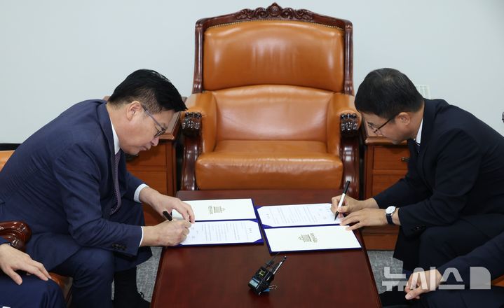 [서울=뉴시스] 최진석 기자 = 한병도 더불어민주당 대표 직무대행 겸 원내대표와 정점식 국민의힘 원내대표가 21일 국회 운영위원장실에서 제9회 전국동시지방선거 투표용지 부족 사태 등 선거관리 부실 사태의 진상규명을 위한 특별검사의 임명 등에 관한 법률안 합의문에 서명하고 있다. (공동취재) 2026.07.21. photo@newsis.com