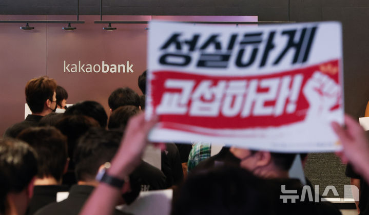 [성남=뉴시스] 김명년 기자 = 민주노총 화섬식품노조 카카오지회 조합원들이 21일 카카오뱅크가 입주한 경기 성남시 판교테크원에서 사측의 임금 인상률과 성과급 등 보상 체계를 규탄하는 피켓 시위를 하고 있다. 2026.07.21. kmn@newsis.com