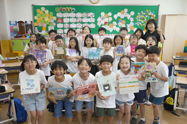 [울산=뉴시스] 울산 청솔초 2학년 1반 학생들이 21일 '무인 책방'에 있는 책을 들고 기념사진을 찍고있다. (사진=울산시교육청 제공) 2026.07.22 photo@newsis.com *재판매 및 DB 금지