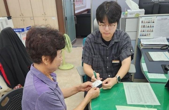 [영동=뉴시스] 충북 영동군 양강면사무소 직원이 22일 전직원이 쓰는 공용 명함을 민원인에게 주고 있다. 면사무소는 사무소 주소와 대표전화 등을 기재하고 이름과 소속 부서와 본인 이름을 적을 수 있도록 만든 명함을 쓰고 있다. (사진=양강면사무소 제공) 2026.07.22. photo@newsis.com *재판매 및 DB 금지