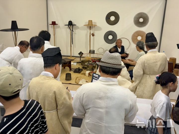 [부산=뉴시스] 한이재 기자 = 22일 부산 벡스코 제1전시장 '대한민국관'에서 옥산서원 관계자들이 갓일(입자) 박창영 보유자의 시연을 지켜보고 있다. 2026.07.22. nowone@newsis.com