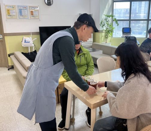 [서울=뉴시스] 서울 강서구 치매안심센터 초록기억카페에서 한 참여자가 이용자에게 음료를 건네고 있다. (사진=서울시 제공) 2026.07.23. photo@newsis.com *재판매 및 DB 금지