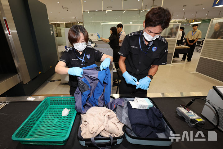 [인천공항=뉴시스] 김명년 기자 = 22일 인천국제공항 제1여객터미널 집중검사실에서 관세청 직원이 수하물 속 밀수 마약 적발 장면을 시연하고 있다.(공동취재) 2026.07.21. kmn@newsis.com