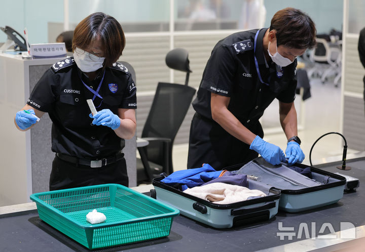 [인천공항=뉴시스] 김명년 기자 = 22일 인천국제공항 제1여객터미널 집중검사실에서 관세청 직원이 수하물 속 밀수 마약 적발 장면을 시연하고 있다.(공동취재) 2026.07.21. kmn@newsis.com