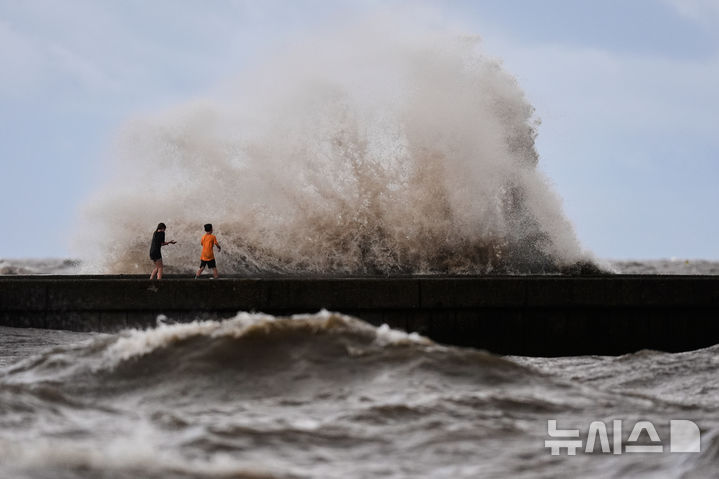 [뉴올리언스=AP/뉴시스] 미 루이지애나주 해안으로 7월 22일 열대성 폭풍 '버사'(Bertha)가 접근하는 가운데, 뉴올리언스 폰차트레인 호 방파 시설에서 어린이들이 거센 파도를 바라보며 놀고 있다. 2026.08.28.