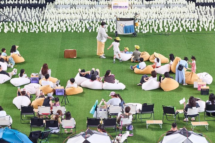 [부산=뉴시스] 지난 18일 부산 영화의전당에서 개최된 '2026 대한민국 밤밤페스타 IN 부산' 행사에서 방문객들이 빈백에 앉아 기증 도서를 읽고 있다. (사진=부산관광공사 제공) 2026.07.23 photo@newsis.com *재판매 및 DB 금지