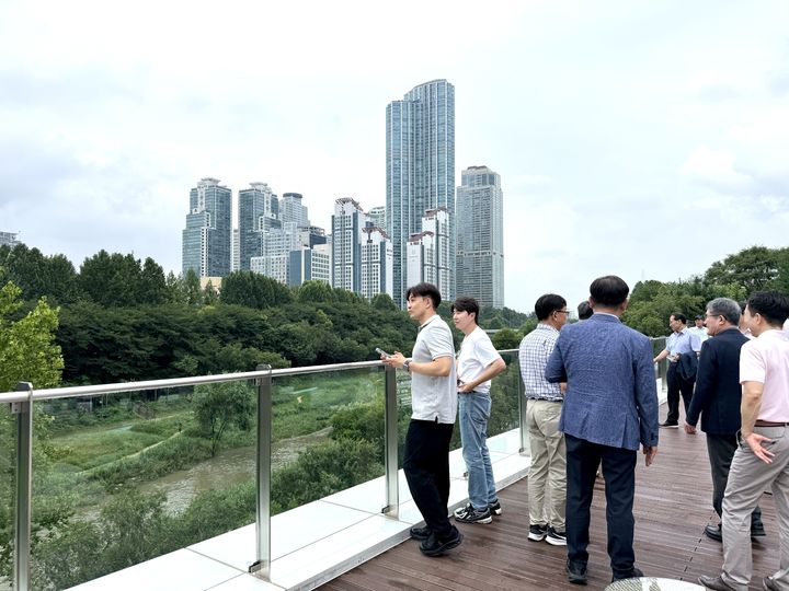 [서울=뉴시스] 서울시 G3 서울플랜 기획위원회 건강활력도시분과 관계자들이 지난 22일 서울 강남구 양재천 수변문화쉼터 옥상전망대에서 주변 수변·녹지 공간을 살펴보고 있다. (사진=서울시 제공) 2026.07.23. photo@newsis.com *재판매 및 DB 금지