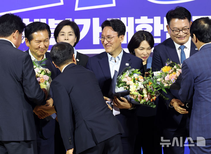 [서울=뉴시스] 최진석 기자 = 더불어민주당 8·17 전당대회 대표 경선에 진출한 정청래(왼쪽부터), 김민석, 송영길 후보가 23일 여의도 국회의원회관에서 열린 당대표·최고위원 선출을 위한 예비경선 결과발표에서 꽃다발을 들고 축하를 받고 있다. 2026.07.23. myjs@newsis.com