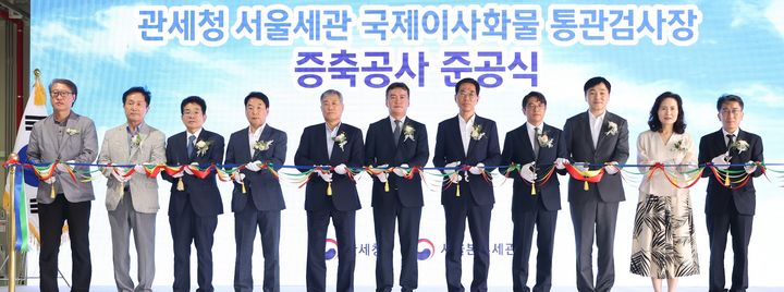 [서울=뉴시스] 24일 서울세관 국제이사화물 통관센터에서 열린 '국제이사화물 통관검사장 증축공사 준공식'서 이종욱 관세청장(왼쪽서 여섯째)이 참석자들과 테이프 컷팅을 하고 있다.(사진=관세청 제공) *재판매 및 DB 금지