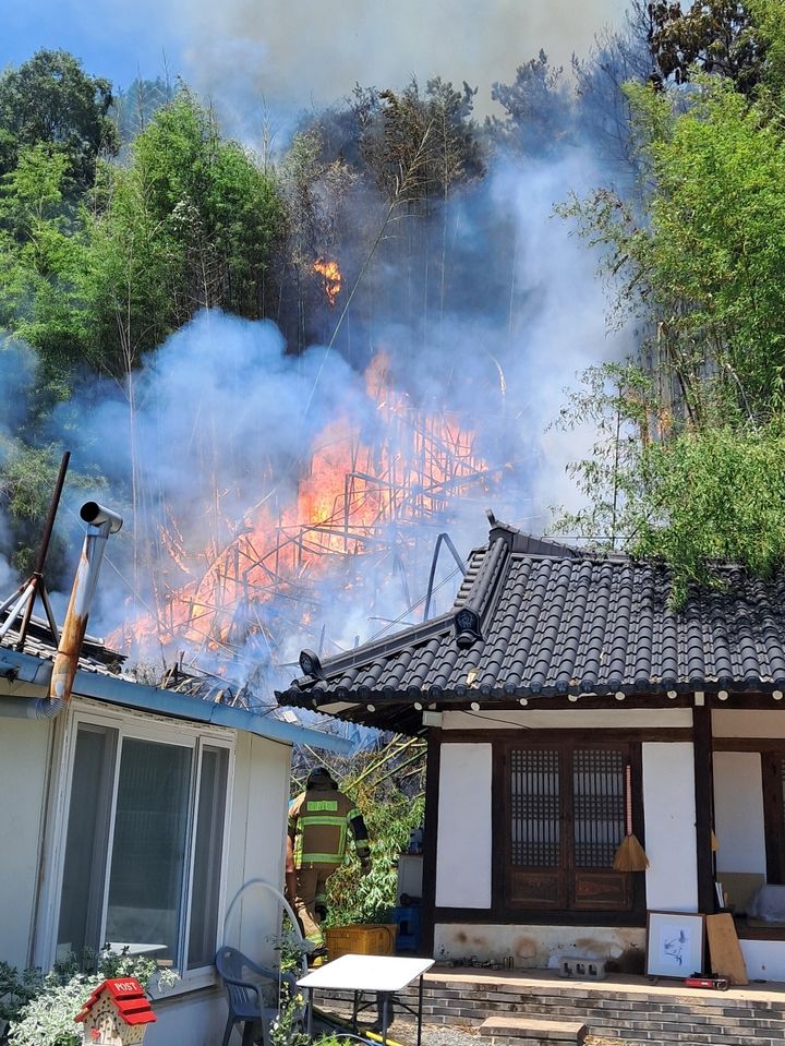 [울산=뉴시스] 구미현 기자 = 24일 오후 12시 36분께 울산시 울주군 두동면의 한 야산에서 발생한 산불 불씨가 민가까지 내려오고 있다. 2026.07.24. (사진=울산소방본부 제공) photo@newsis.com *재판매 및 DB 금지
