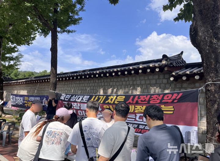 [서울=뉴시스] 이우경 인턴기자=고양창릉 S4 블록 사전청약 당첨자들이 본격적인 집회·시위에 앞서 현장 접수대에서 참가자 본인 확인 및 신원 명부를 작성하고 있다. 2026.07.24.