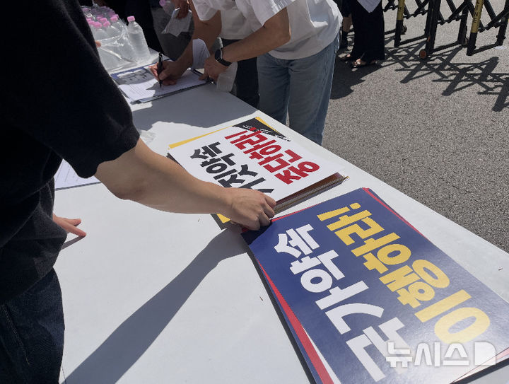 [서울=뉴시스] 이우경 인턴기자=피켓 문구(‘국가약속 이행하라!’, ‘거짓약속 중단하라!’)가 테이블에 놓여져 있다. 2026.07.24.