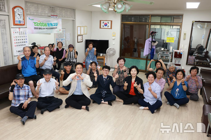 [군포=뉴시스] 산본2동 개나리 경로당을 방문한 시 의원들이 사랑의 하트를 그리며 기념 촬영을 하고 있다. (사진=군포시 의회 제공).2026.07.23. photo@newsis.com