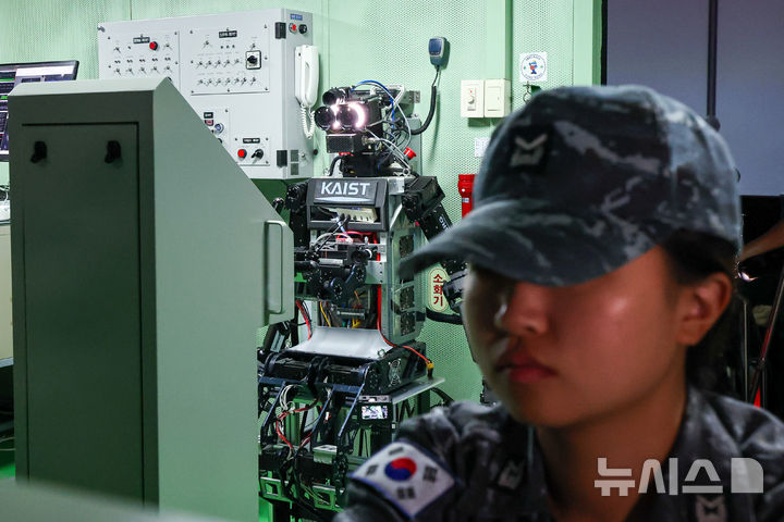 [창원=뉴시스] 사진공동취재단 = 23일 경남 창원 진해구 해군교육사령부 조함훈련장 시뮬레이터에서 진행된 ‘해상 당직업무 수행 로봇 전투실험’에서 한국과학기술원(KAIST)이 개발한 인간형 로봇(휴머노이드) ‘파이봇(PIBOT)’이 조타수 임무를 수행하고 있다. 2026.07.24. photo@newsis.com