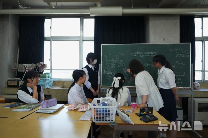 Art teacher Makiko Aoki, second right, teaches chalk drawing skills to freshman members of the art club at Kumagaya Girls High School in Kumagaya, northwest of Tokyo, Tuesday, July 21, 2026. (AP Photo/Hiro Komae)