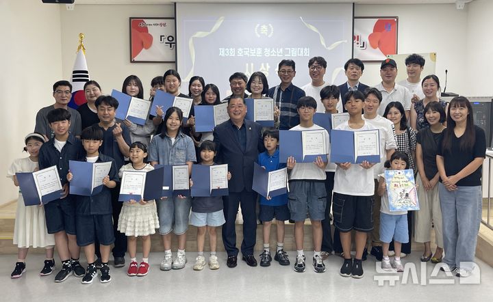 [창원=뉴시스]지난 24일 오후 경남 창원시종합자원봉사센터 대강당에서 남창원팔각회 제3회 호국보훈 청소년 그림대회 수상자 및 김건 남창원팔각회 회장 등 참석자들이 기념촬영하고 있다.(사진=남창원팔각회 제공) 2026.07.25. photo@newsis.com 