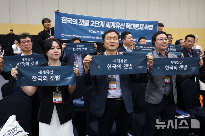 [부산=뉴시스] 박진희 기자 = 한국의 갯벌 세계유산 등재추진단이 25일 오후 부산 해운대구 벡스코(BEXCO)에서 '한국의 갯벌' 등재를 기뻐하고 있다. 2026.07.25. pak7130@newsis.com