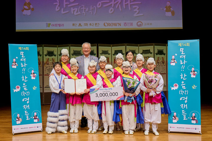 [서울=뉴시스] 25일 서울 용산구 남산국악당 크라운해태홀에서 열린 '제14회 모여라 한음(국악)영재들 경연대회'에서 크라운해태 윤영달 회장(뒷줄 왼쪽 두번째)이 종합대상(교육부장관상)을 수상한 '예움전통연희단'과 함께 기념사진을 촬영하고 있다. (사진=크라운해태 제공) 2026.07.26. photo@newsis.com *재판매 및 DB 금지