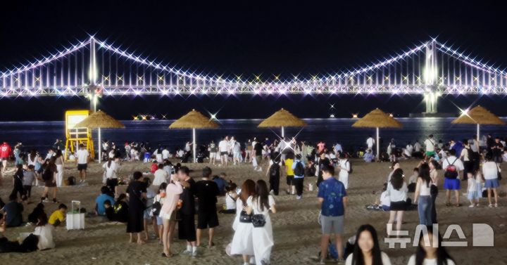  [부산=뉴시스] 하경민 기자 = 본격적인 피서철이자 밤낮으로 푹푹 찌는 더위가 이어진 25일 밤 부산 수영구 광안리해수욕장에서 시민과 관광객들이 더위를 식히고 있다. 부산에는 지난 18일부터 폭염특보가 발효 중이며, 19일부터 열대야 현상이 이어지고 있다. 2026.07.26. yulnetphoto@newsis.com