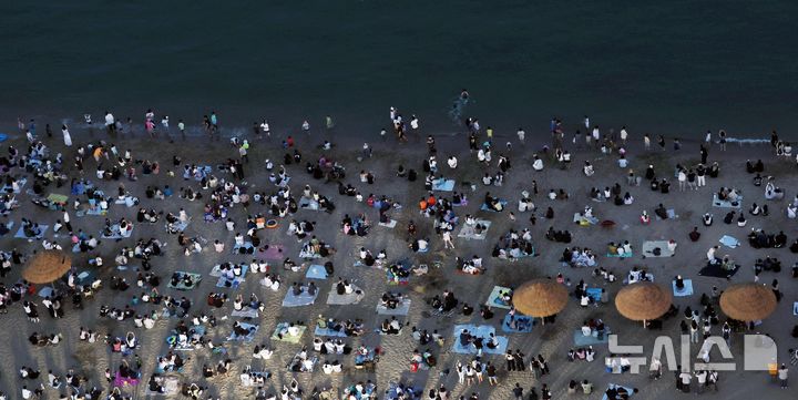  [부산=뉴시스] 하경민 기자 = 본격적인 피서철이자 밤낮으로 푹푹 찌는 더위가 이어진 25일 밤 부산 수영구 광안리해수욕장에서 시민과 관광객들이 더위를 식히고 있다. 부산에는 지난 18일부터 폭염특보가 발효 중이며, 19일부터 열대야 현상이 이어지고 있다. 2026.07.26. yulnetphoto@newsis.com