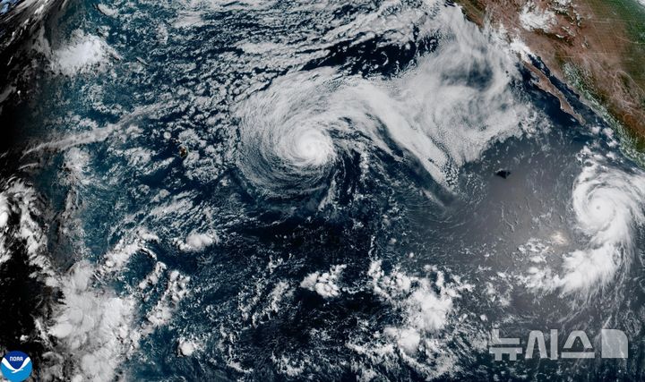 [AP/뉴시스] 미국 해양대기청(NOAA)이 26일 배포한 위성사진으로 오른쪽 아메리카 대륙에 가까운 동태평양에 허리케인 2개가 움직이고 있다. 하와이 부근에서 허리케인 파우스토, 멕시코 바하캘리포니아 반도 해안 부근에서 허리케인 제네비브가 보인다 