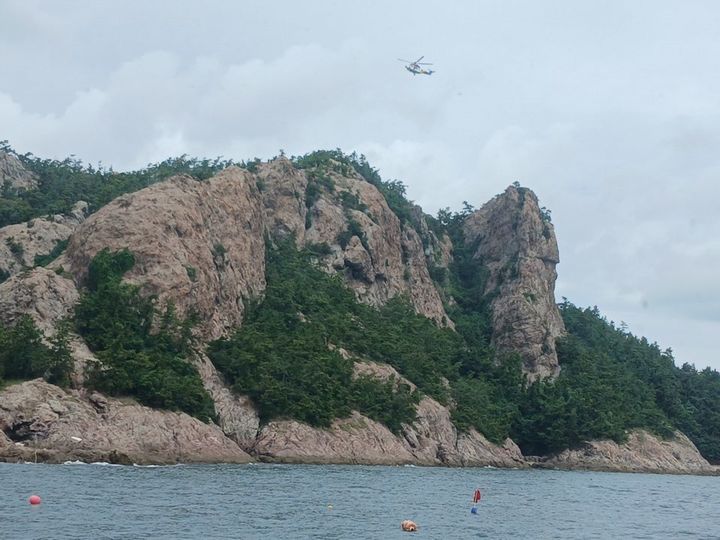 [군산=뉴시스] 27일 오전 9시49분께 전북 군산시 옥도면 선유도에 위치한 봉우리인 선유봉에서 등산객이 추락해 해양경찰 헬기가 구조를 위해 추락지점 인근을 배회하고 있다. (사진=전북특별자치도소방본부 제공) 2026.07.27. photo@newsis.com *재판매 및 DB 금지