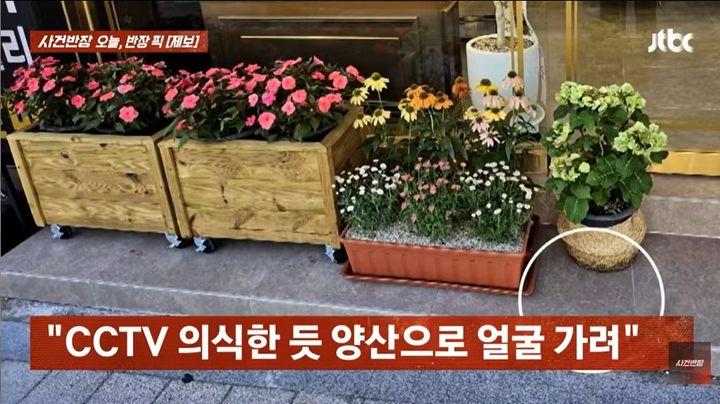 [서울=뉴시스] 지난 26일 JTBC '사건반장'에서 공개한 영상에는 부산의 한 가게 앞에서 한 여성이 양산으로 얼굴을 가린 채 화분을 들고 사라지는 모습이 담겼다. (사진=JTBC 유튜브 채널 '사건반장' 캡처)