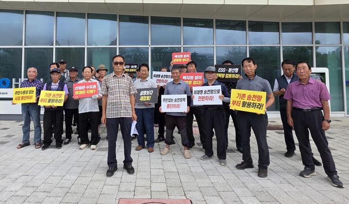[청주=뉴시스] 충북 청주시 흥덕구 옥산면 주민들로 구성된 송전선로 반대 옥산면 주민 공동 대책위원회가 27일 충북바이오산학융합원 앞에서 한국전력공사의 일방적인 송전선로 후보 경과지 결정 등에 반발하는 피켓 시위를 하고 있다. (사진=대책위원회 제공) 2026.07.27. photo@newsis.com *재판매 및 DB 금지