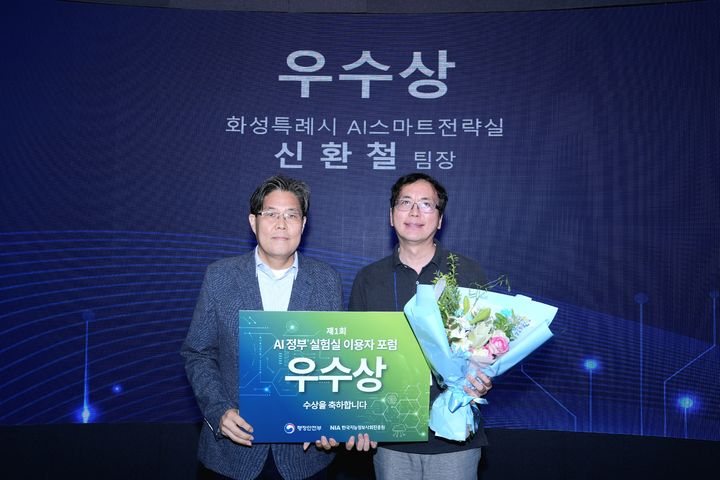 [화성=뉴시스] 신환철 화성시 AI스마트전략실 빅데이터팀장(사진 오른쪽)이 제1회 AI정부실험실 이용자포럼에서 우수상을 수상한 뒤 기념촬영을 하고 있다. (사진=화성시 제공) 2026.07.27. photo@newsis.com *재판매 및 DB 금지