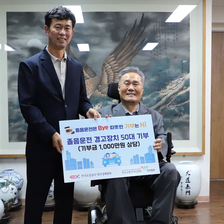 [대구=뉴시스] 유호식((왼쪽) 한국도로공사 대구경북본부장이 김락환 한국교통장애인협회장에게 졸음운전 경고장치를 전달하고 있다. (사진=한국도로공사 제공) 2026.07.27 photo@newsis.com *재판매 및 DB 금지