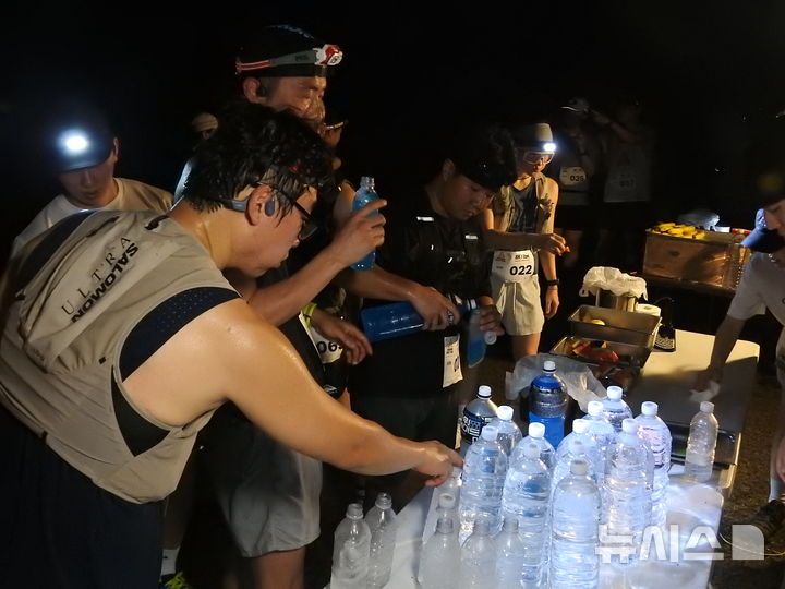 [제주=뉴시스] 김수환 기자 = 25일 오후 제주시 애월읍 궷물오름 주차장에서 제주 아웃도어 커뮤니티 '구보(goobo)'가 주관한 '노꼬메 나이트 트레일' 행사가 열린 가운데 참가자들이 보급지점(CP) 지점에서 수분을 섭취하고 있다. 2026.07.27. notedsh@newsis.com