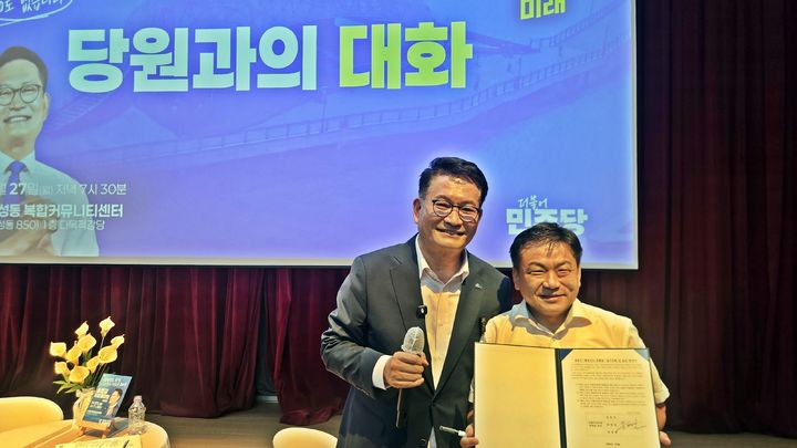 [세종=뉴시스] 송승화 기자 = 27일, 송영길 더불어민주당 대표 후보가 세종시 나성동 복합커뮤니티센터에서 열린 타운홀미팅에서 당원이 들어온 '행정수도 특별법 당론 채택 확인서'에 서명하고 사진을 찍고 있다. 2026.07.27. ssong1007@newsis.com *재판매 및 DB 금지